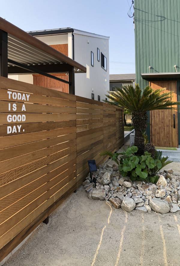 木製のフェンスと「今日いい日」と書かれた看板